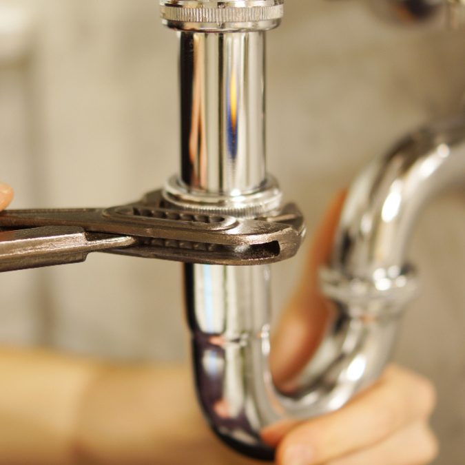 Plumber tightening pipe in Somerton and Glastonbury